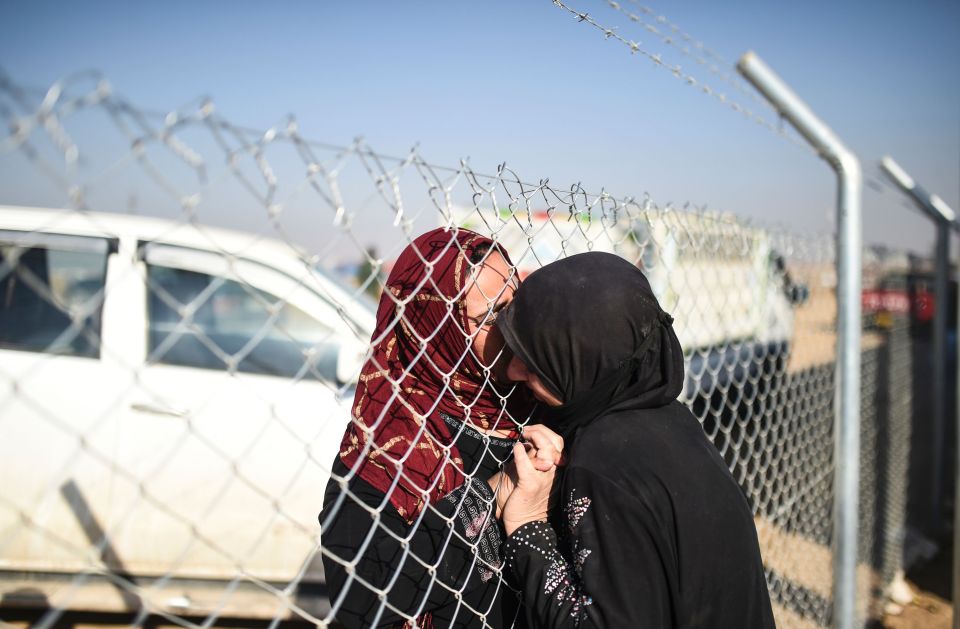 An Iraqi woman (L) embraces relative who