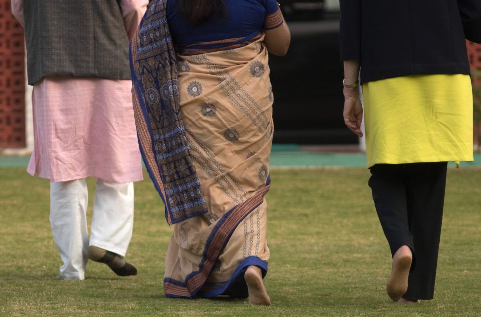 Theresa May ditches her trademark kitten heels as she pays her respects in New Delhi