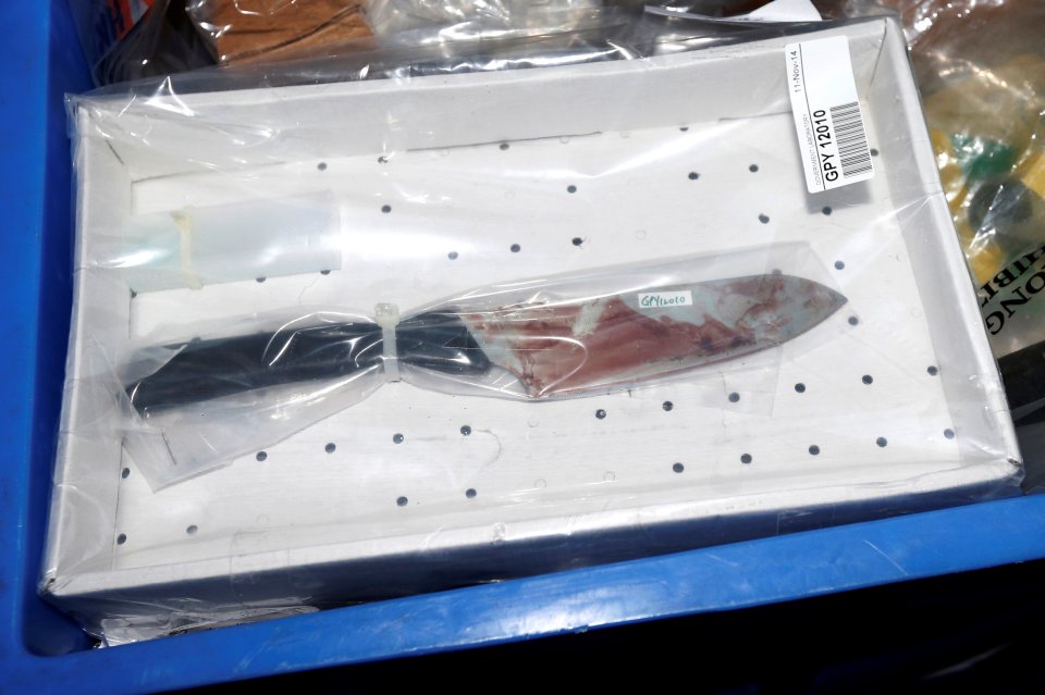 A bloodstained knife, as part of evidence, is pictured outside the High Court as police carry it away after double murder trial of British former banker Jutting in Hong Kong