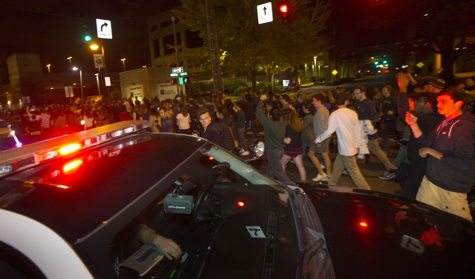 Police block traffic for a rally against President-elect Donald Trump as people march down a street east of the University of Oregon campus in Eugene