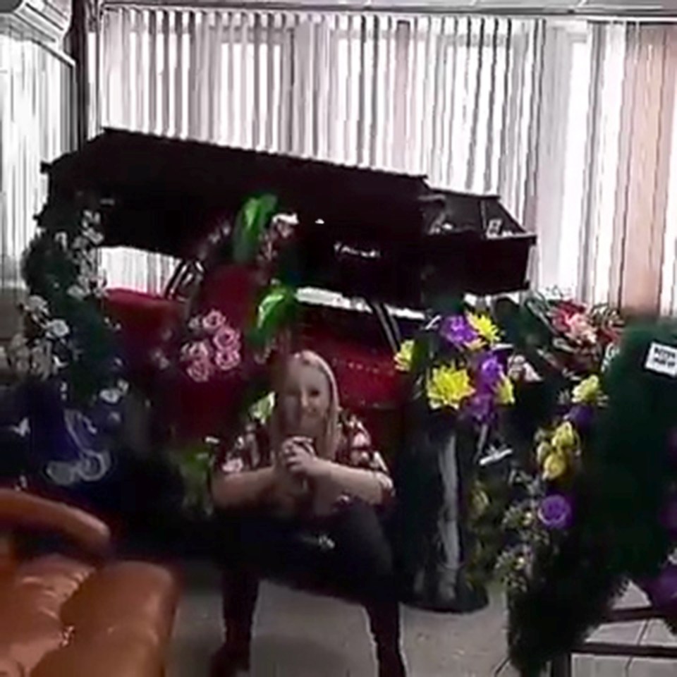 Anastasia Myakina does squats next to coffins at the funeral parlour