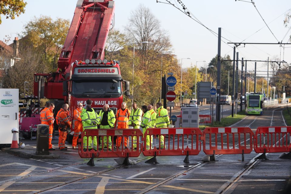 Workers at the site of the Croydon tram crash stand during a two minute silence to mark Armistice Day