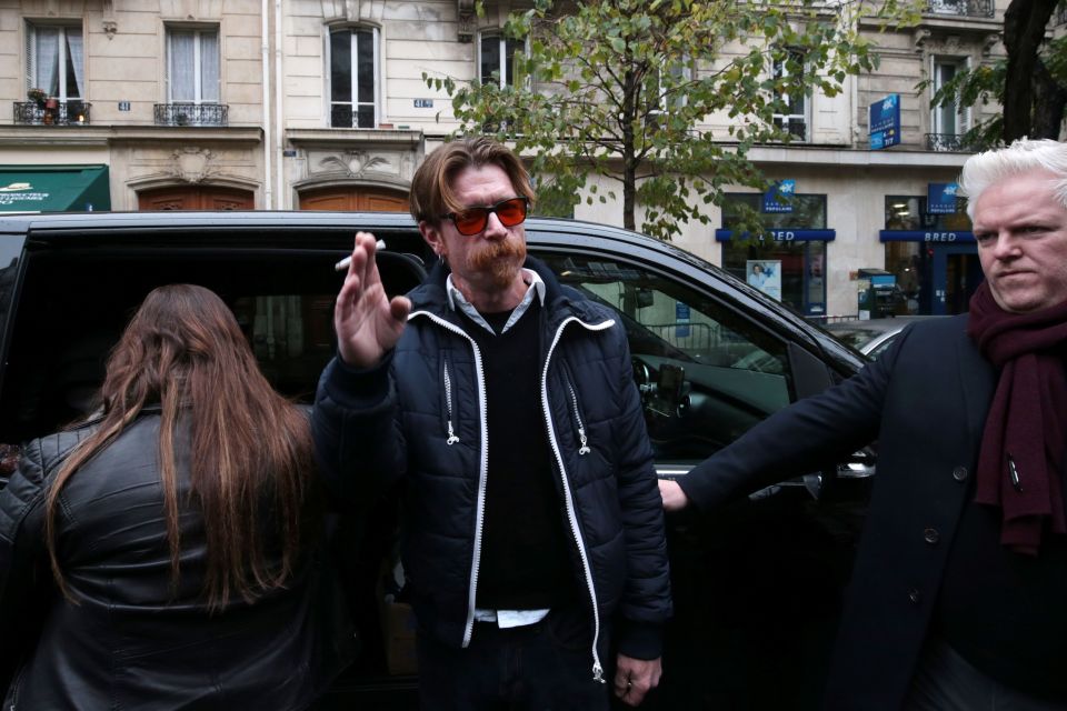 Mr Hughes and band member Josh Homme on their way to a memorial ceremony near the Bataclan 