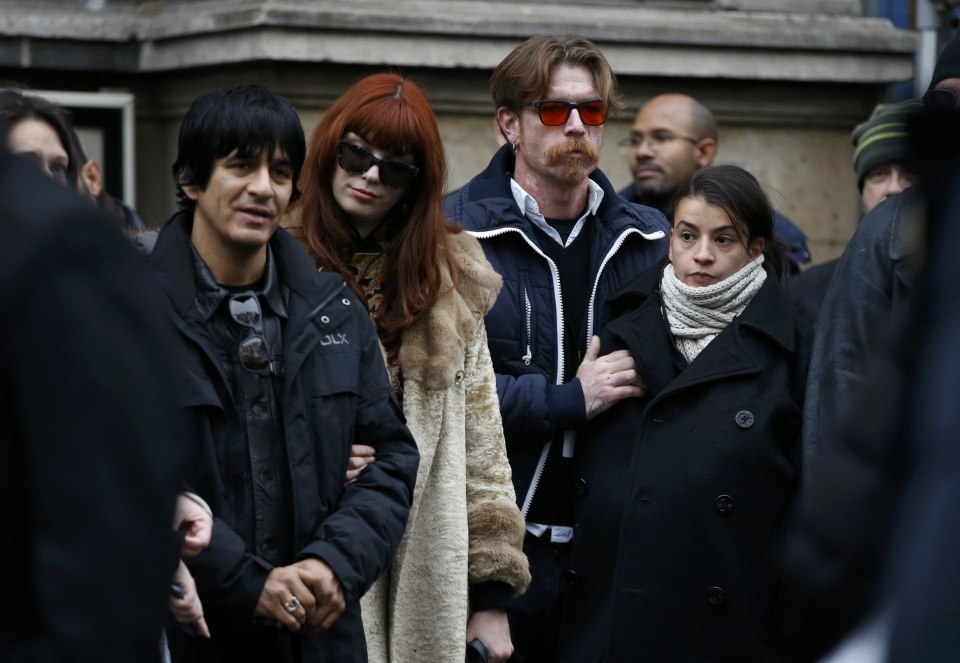 Eagles of Death Metal band and relatives including Jesse Hughes (C) stand in front of Paris 11th district town hall