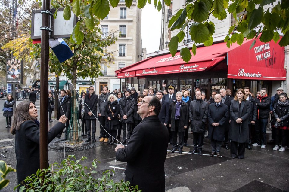 President Francois Hollande (C) an Mayor of Paris Anne Hidalgo (L) unveil a commemorative plaque in front of the 'Comptoir Voltaire' 