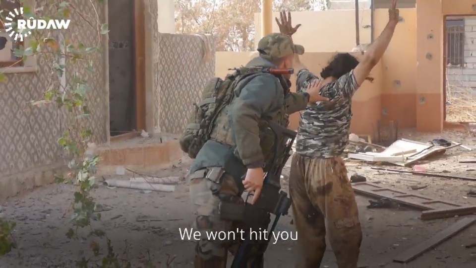 A nervous Kurdish soldier then frisks the man