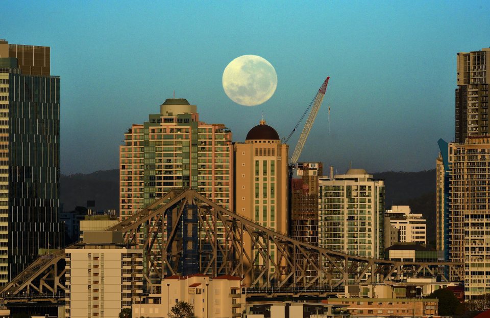 A supermoon sets over the Brisbane skyline, Australia, early on Tuesday morning