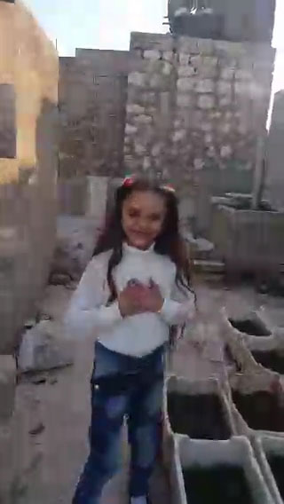 Little Bana smiles even as bombs and rockets explode around her