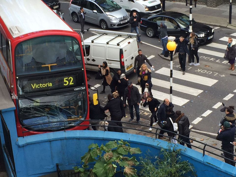 A woman was left trapped underneath a bus and 13 others were injured when it swerved off the road to avoid a collision 