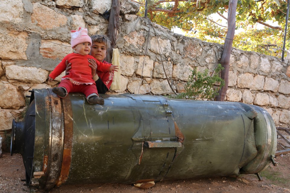 Children play on an unexploded Russian rocket, Anjara, Syria - 18 Nov 2016