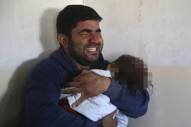 Unimaginable horror... An Iraqi man clutches his dead daughter to his chest