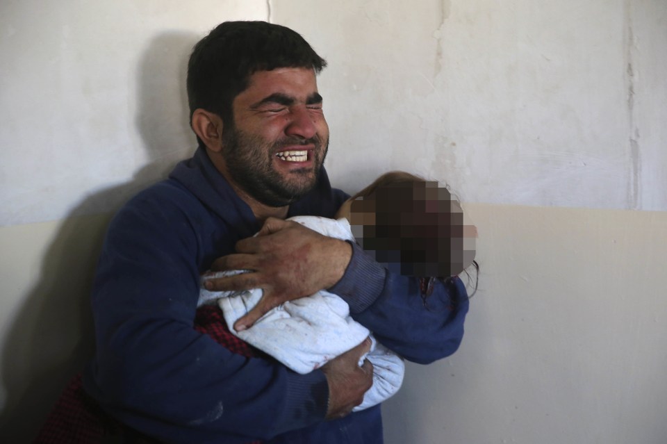 Unimaginable horror... An Iraqi man clutches his dead daughter to his chest