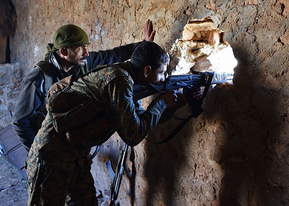 A fighter from the Syrian pro-government forces wields a rifle