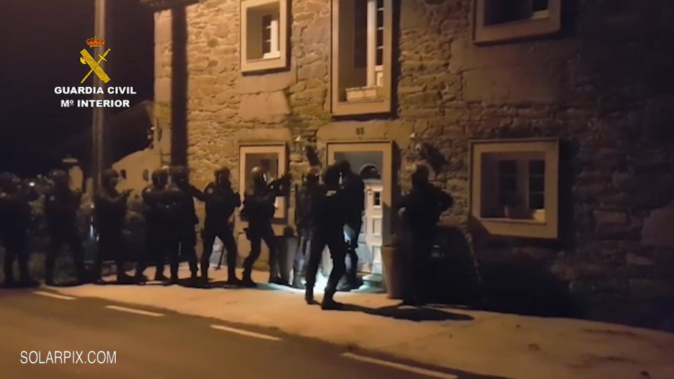 Armed police stormed the home of suspected human traffickers in Spain on Monday