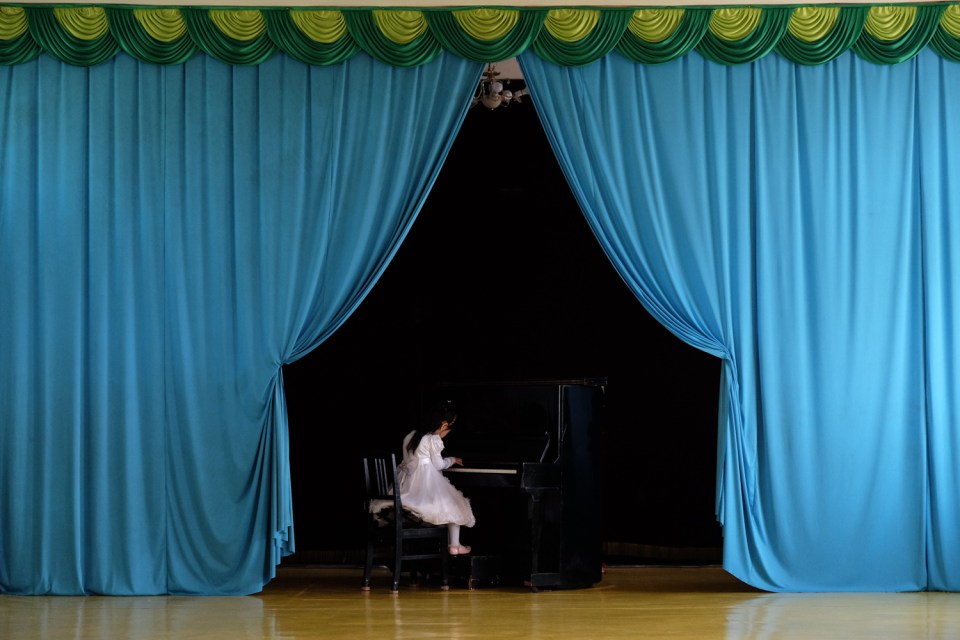 Young girl playing piano during a kindergarten perfomance in Chongjin