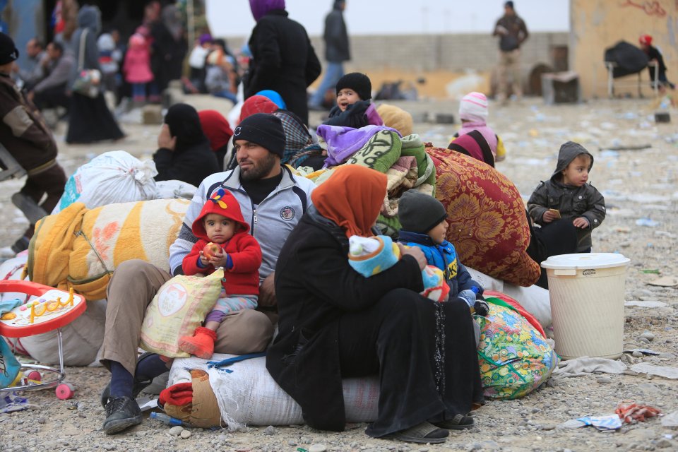 Displaced people who fled the clashes wait for transfer to camps during a battle with Islamic State militants in Mosul