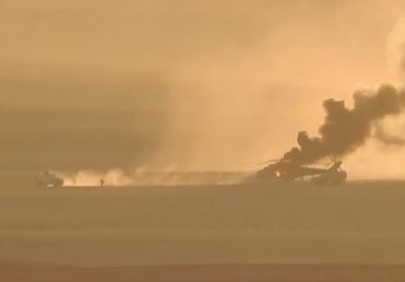 One of the armoured cars takes off in reverse while troops flee