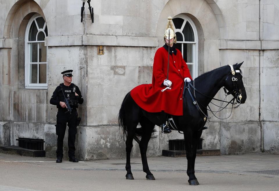 An armed officer watches on during the traditional ceremony