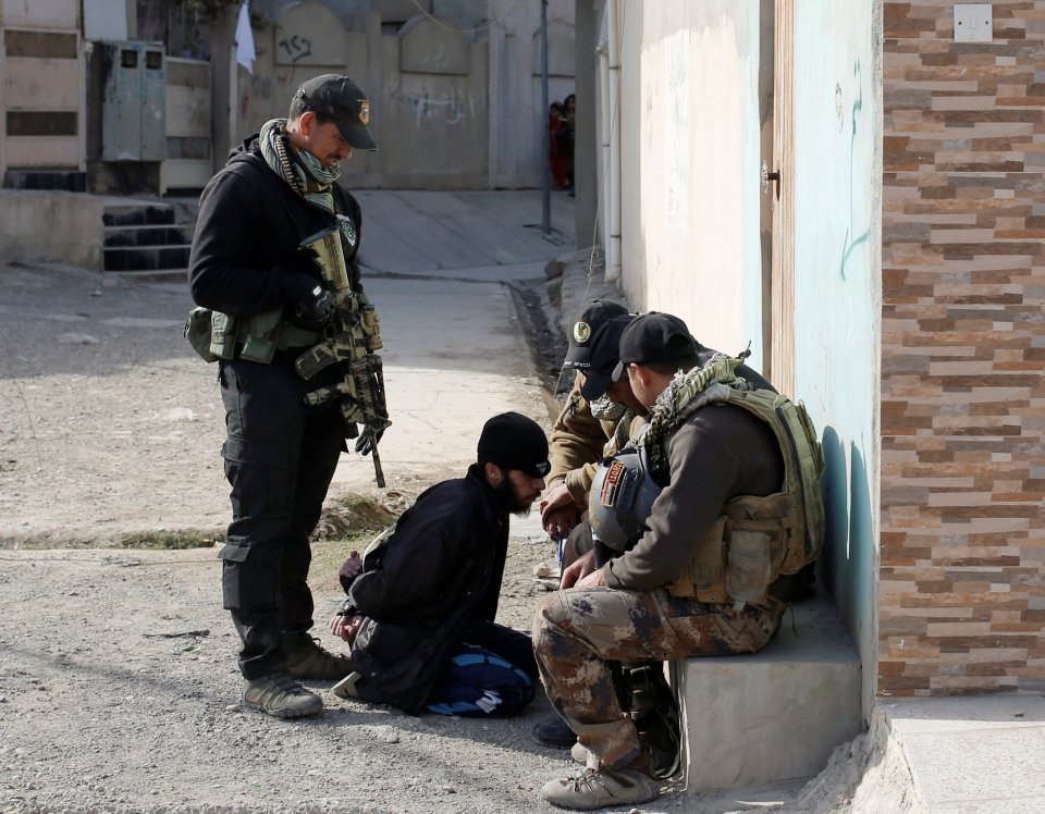 Members of an Iraqi Special forces intelligence team talk to suspected Islamic State fighter in Mosul, Iraq 