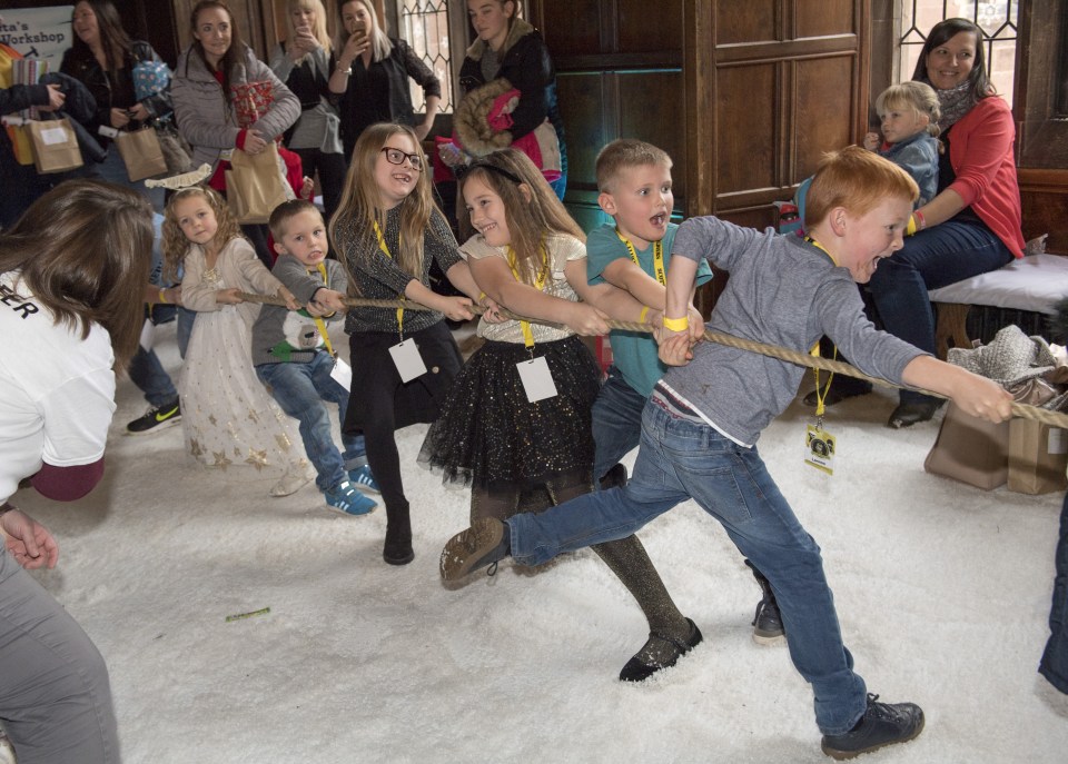 Festive cheer . . . kids join in with a tug-of-war at charity party