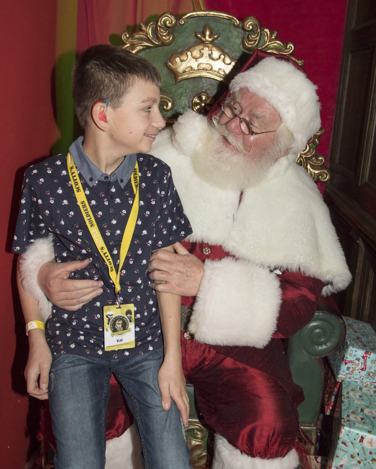 Ho, Ho, Ho . . . brave little lad joins Santa for a festive chat