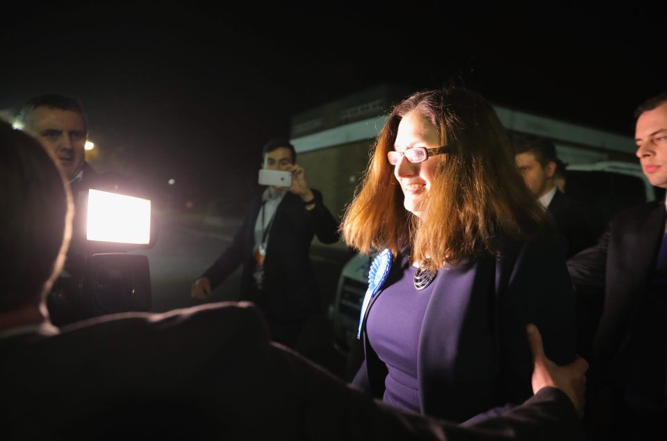 Doctor Caroline Johnson is ushered away as media try to get her to answer questions after she won the parliamentary seat
