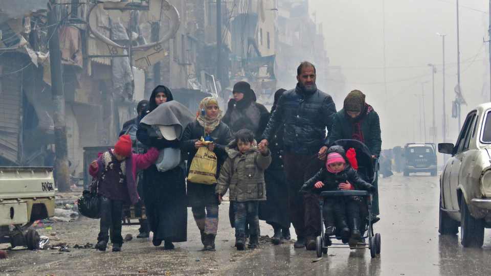 Syrian residents, fleeing violence in the Bustan al-Qasr neighbourhood, arrive in Aleppo's Fardos neighbourhood