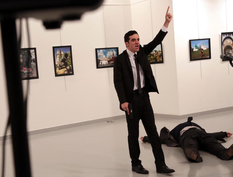 The gunman gestures after shooting the Russian Ambassador to Turkey