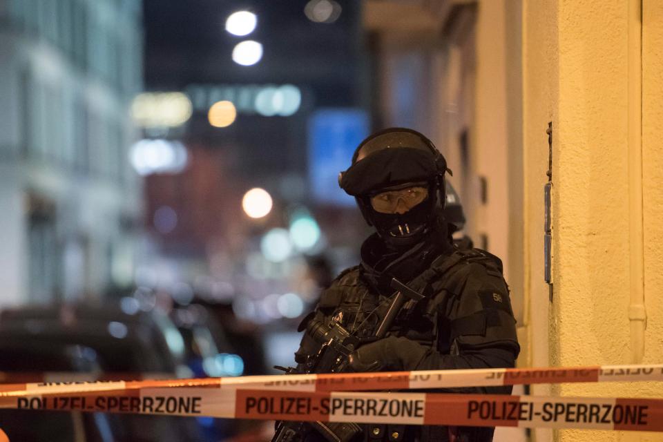  An armed cop stands guard behind a cordon at the scene