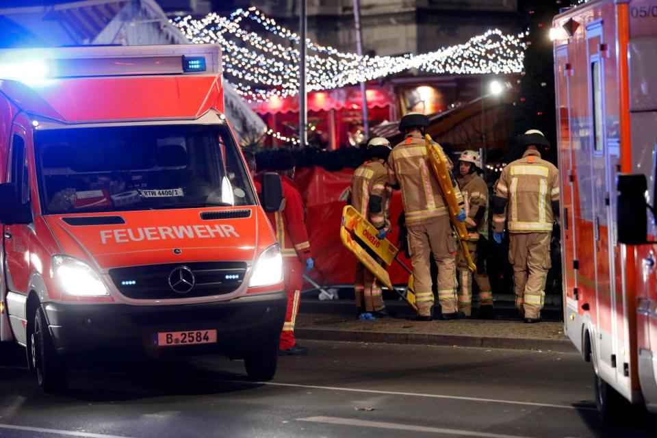  Firefighters carrying stretchers attend the carnage at the Christmas market