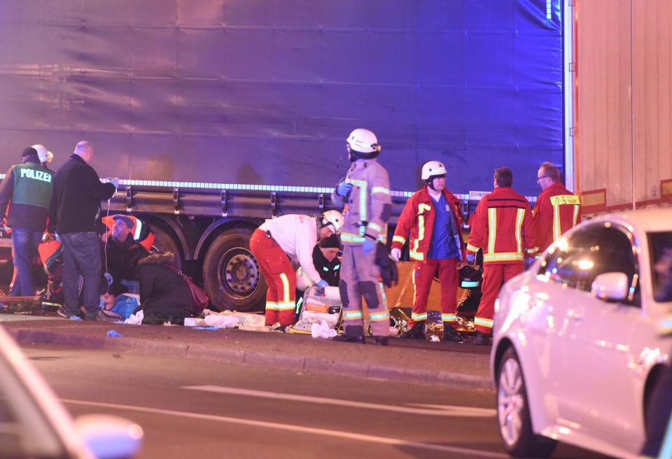  Rescuers work to free casualties still trapped underneath the truck