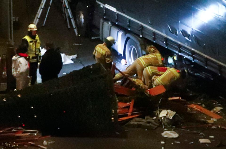 Authorities inspect the truck after the devastating crash left a dozen dead