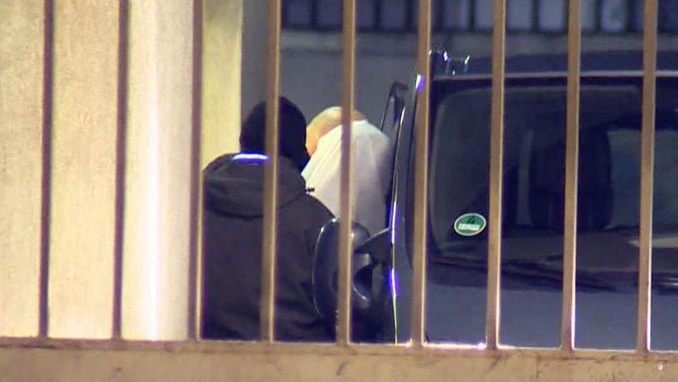  An image of the man incorrectly suspected of carrying out the attack shows him being escorted into custody by police