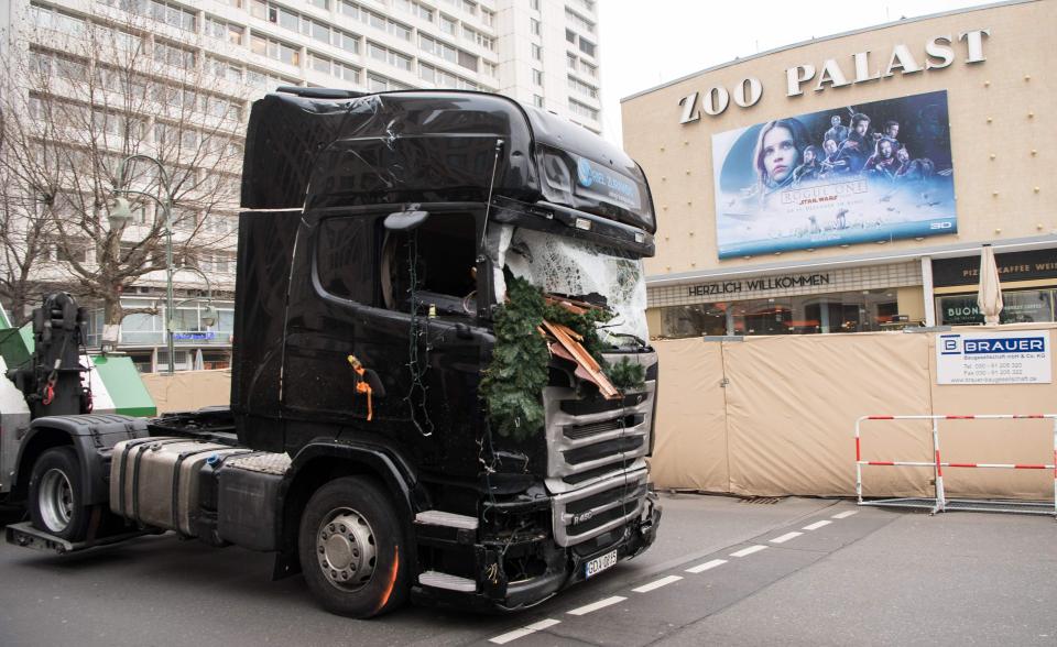  The battered lorry used in the attack was towed away by German police this afternoon