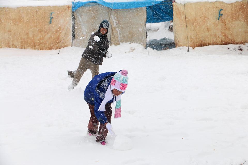 Syrian children have a snowball fight in a city of tents as the town of Azaz is covered in a blanket of snow