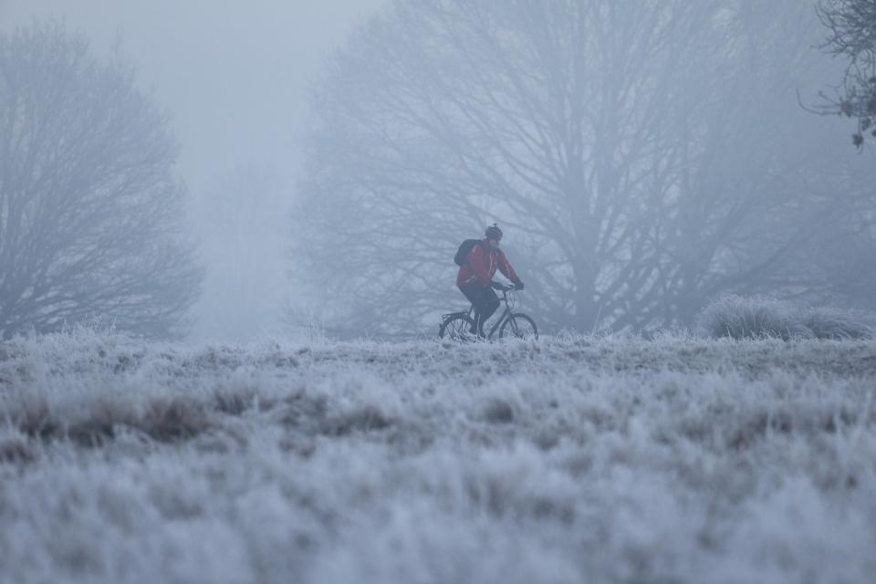 A man braves the chill as he cycles through Richmond Park in south west London this morning