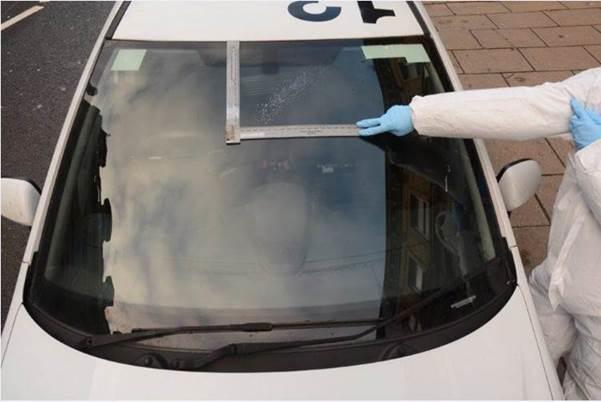 Damage to the police car can bee seen where the bullets grazed the windscreen