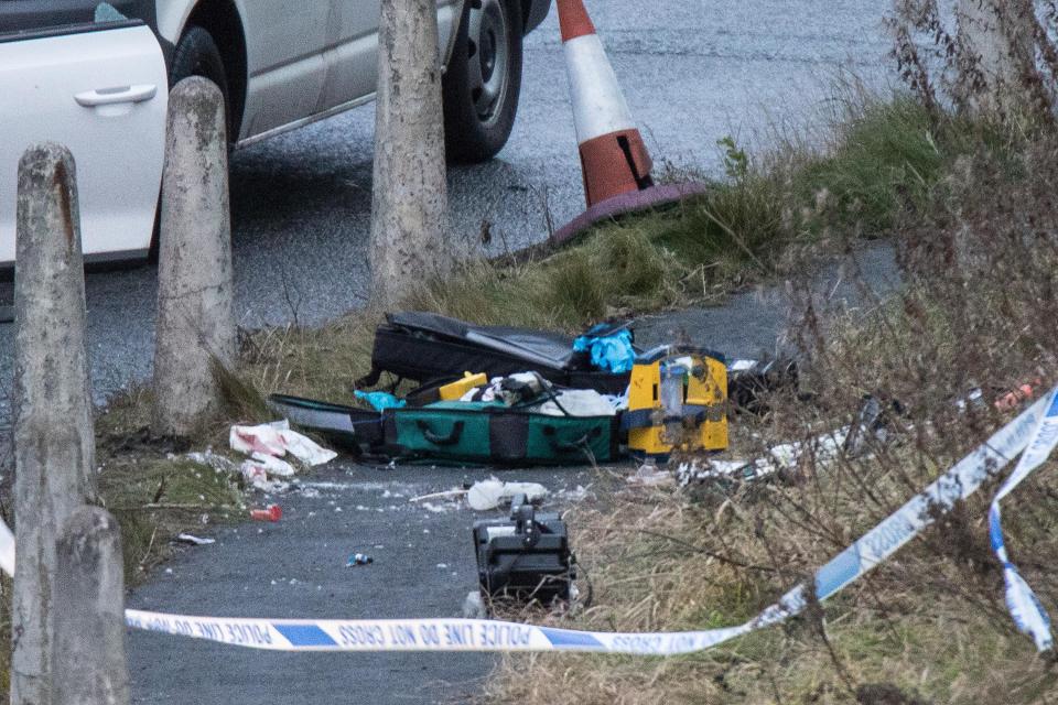 First aid equipment lies on the ground next to the vehicles stopped by police