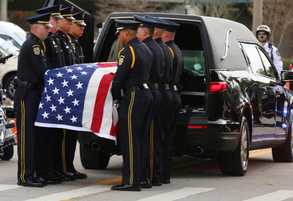 Members of an Orlando Police honour guard prepare to carry the flag draped casket of the slain officer