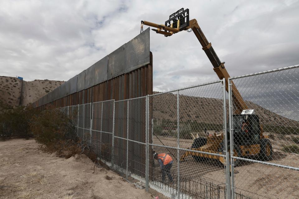 Workers make the fence taller between the towns of Anapra, Mexico and Sunland Park, New Mexico in November 