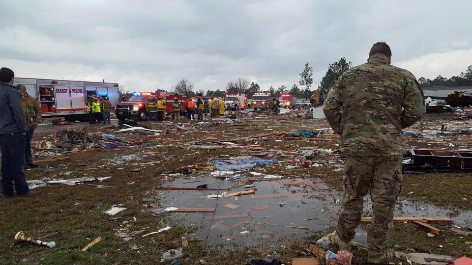 A U.S. Air Force airman surveys debris as emergency services are at the scene in Georgia