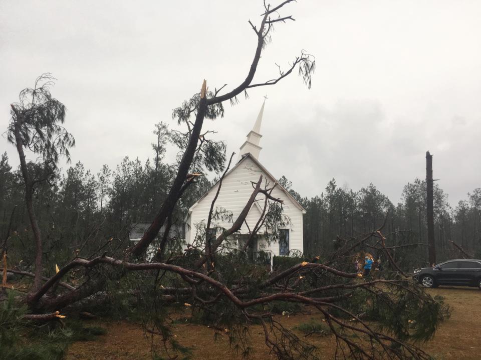Fallen trees sit near Zoar United Methodist Church that sustained damage to its steeple in the storm