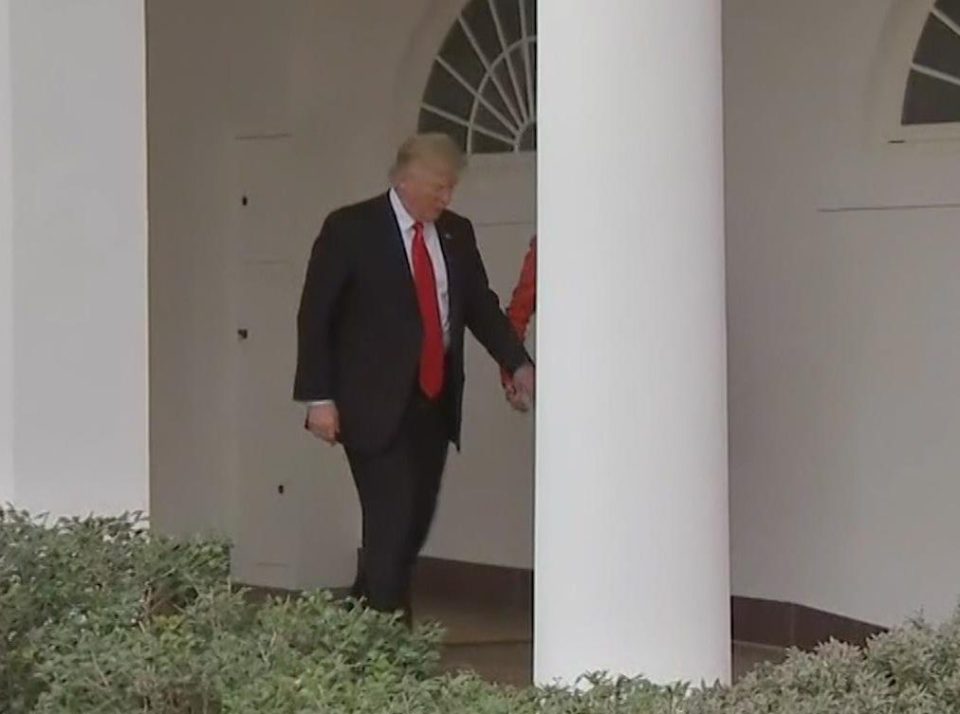  The President was seen snatching for Theresa May's hand before they faced journalists