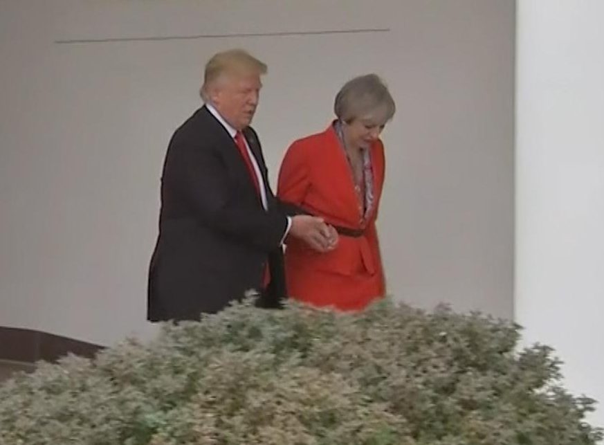  President Donald Trump snatches Theresa Mays hand as they walk through the White House