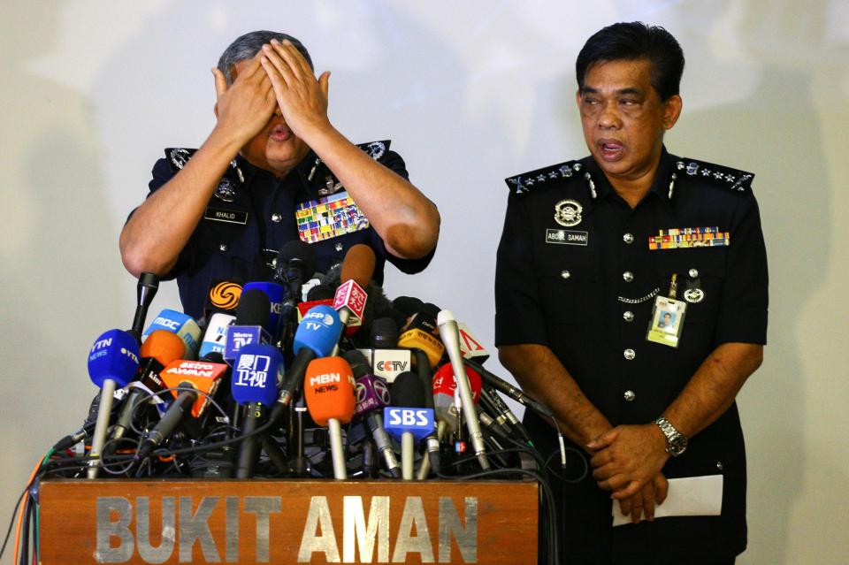 Malaysia's Royal Police Chief Khalid Abu Bakar demonstrates how the women are claimed to have wiped poison on Kim's face