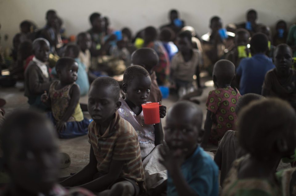 South Sudanese child refugees eat porridge given out by the World Food Programme in Imvepi, Uganda 