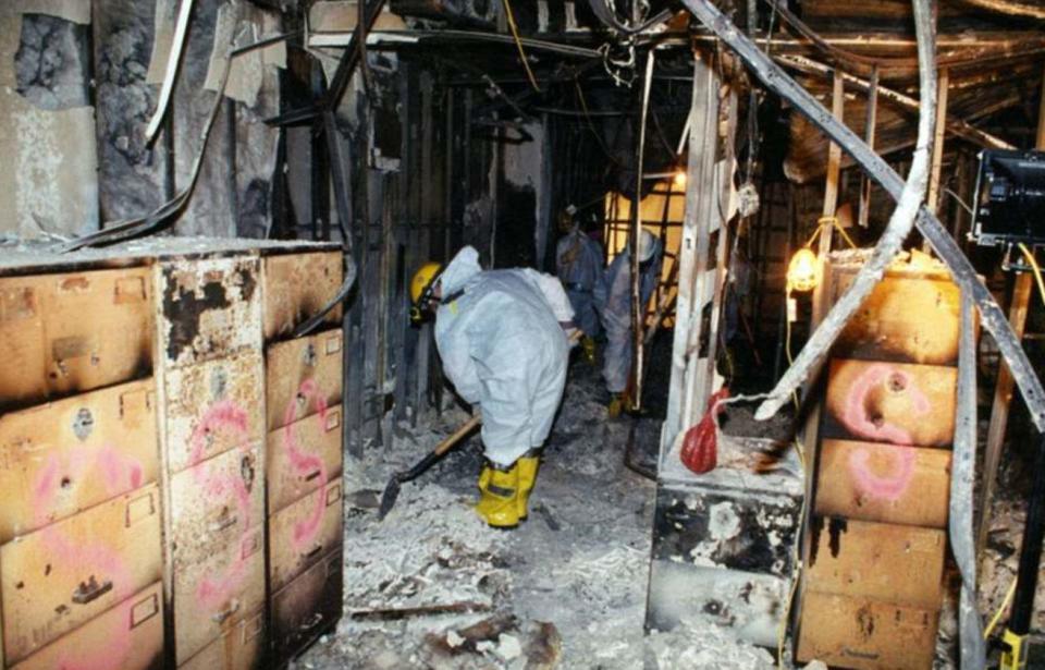  Workers can be seen shovelling through ash and dust left behind after the disaster
