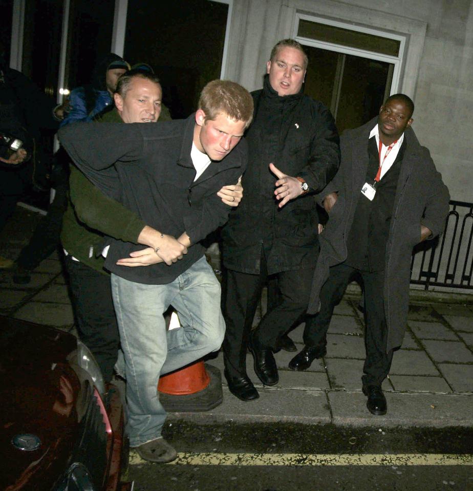  Harry clashes with a photographer at a nightclub in 2004