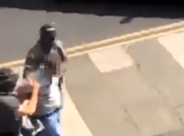 The suspect who police said was carrying a suspicious package is led away