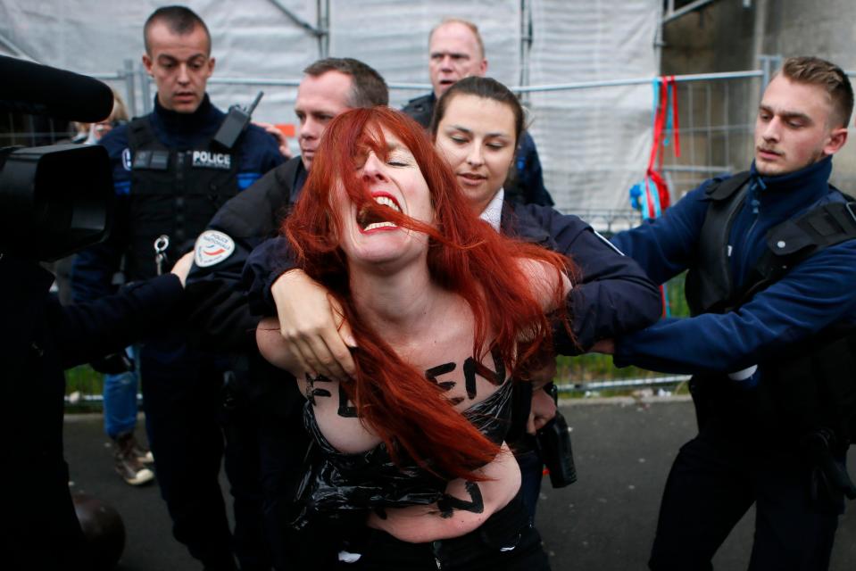  Police arrest a Femen protester after they draped a massive anti-Le Pen banner down the side of a church in Northern France